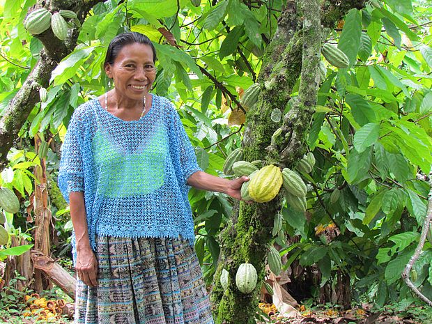 Mujer con fruto de cacao en un sistema agroforestal, ©OroVerde - M. Metz